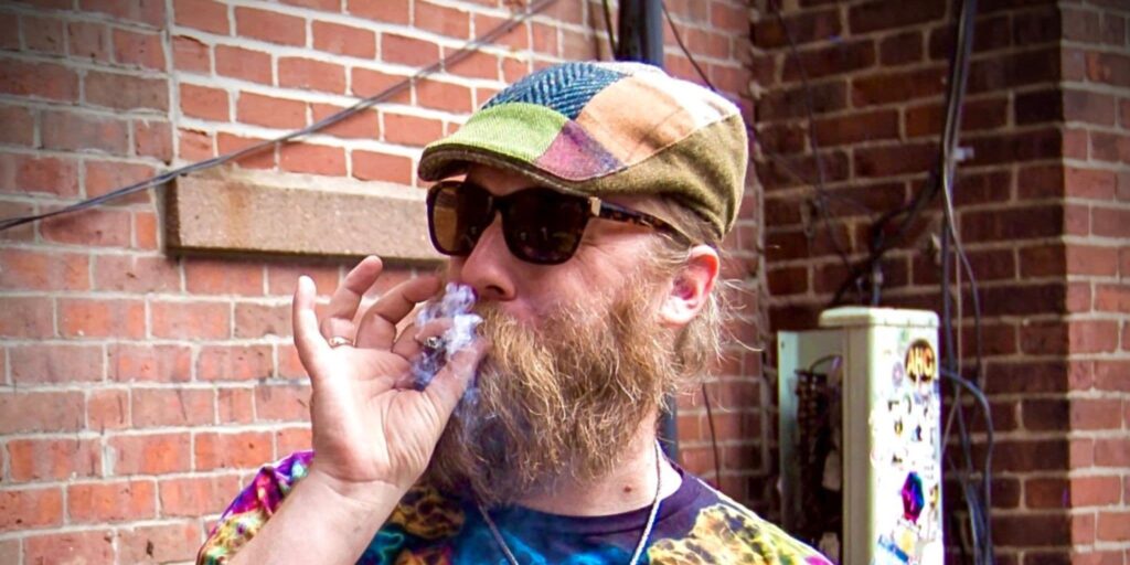 Tye Dyed Tour Guide Smoking a Joint