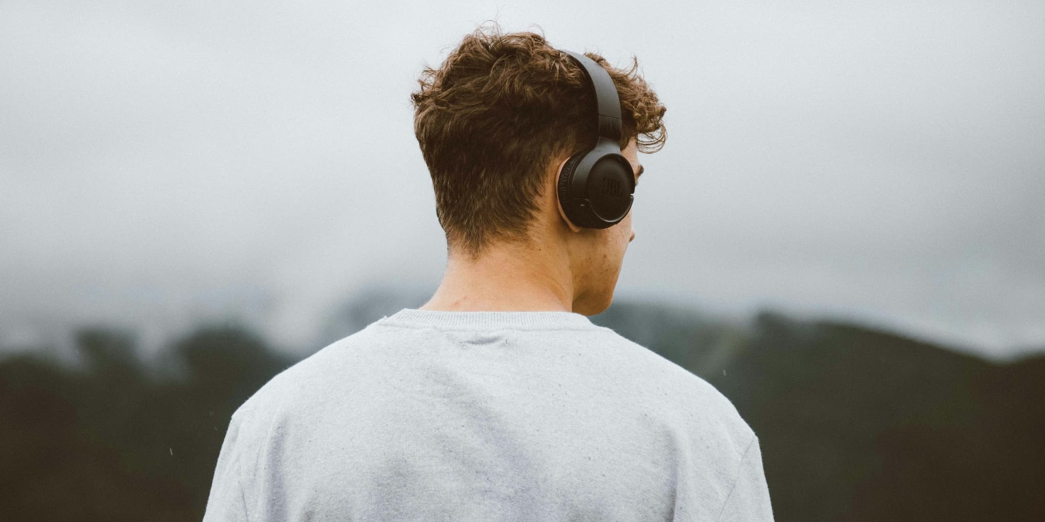 The back of a man's head who's wearing headphones