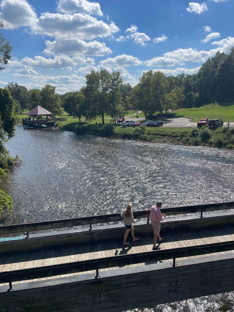 A couple walking along a river on a beautiful day in Ypsilanti, Michigan